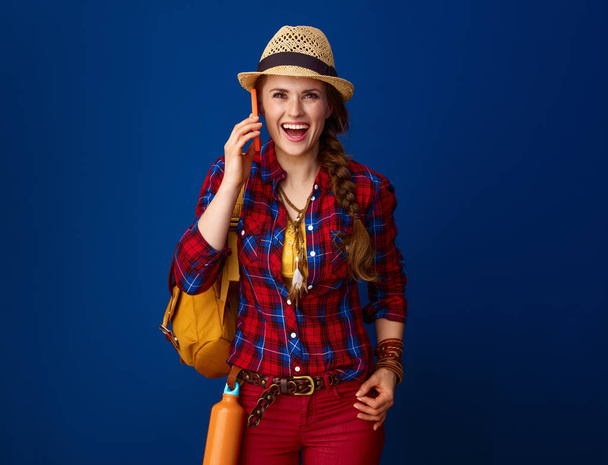 surprised adventure excited woman hiker in a plaid shirt using a smartphone - Foto, Imagen
