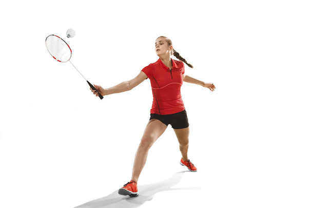 Young woman playing badminton over white background - Foto, immagini
