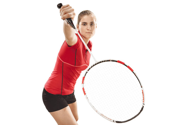 Young woman playing badminton over white background - Foto, afbeelding
