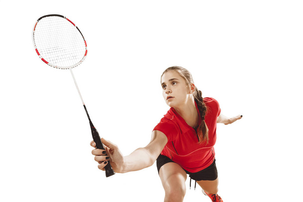 Young woman playing badminton over white background - Фото, изображение