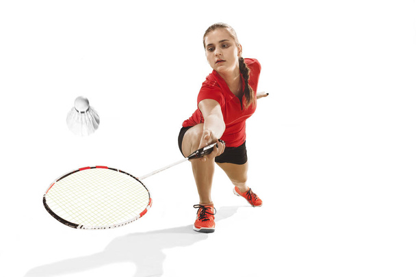 Genç kadın beyaz arka plan üzerinde badminton oynarken - Fotoğraf, Görsel