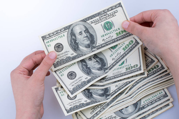 Ludzka ręka trzyma amerykański banknot dolarowy jako pieniądze odizolowane na białym - Zdjęcie, obraz