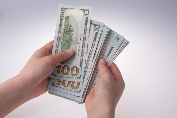 Людська рука тримає американський долар як гроші ізольовані на білому - Фото, зображення