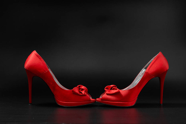 zapatos rojos de las mujeres de la moda sobre un fondo negro
. - Foto, imagen