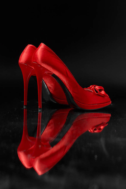 red fashion women shoes on a black background. - 写真・画像