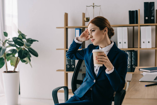 pensive female lawyer in suit with coffee to go at workplace in office - Zdjęcie, obraz