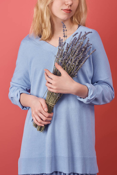 cropped shot of woman with bouquet of lavender flowers isolated on red - Фото, изображение