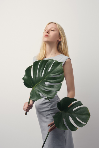 beautiful young woman with monstera leaves isolated on white - Foto, Imagen