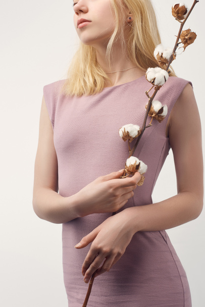 cropped shot of young woman in pink dress with cotton branch isolated on white - Foto, afbeelding