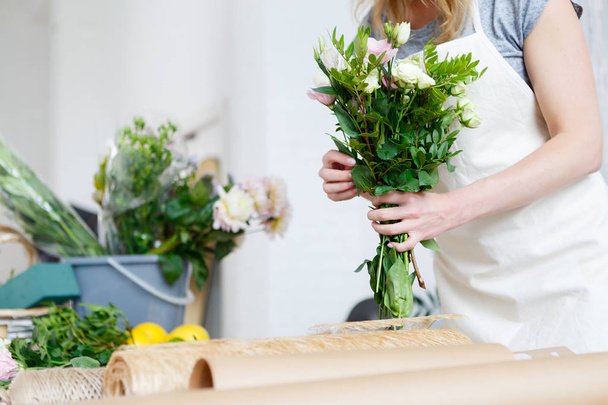 Young woman florist makes bouquet - 写真・画像