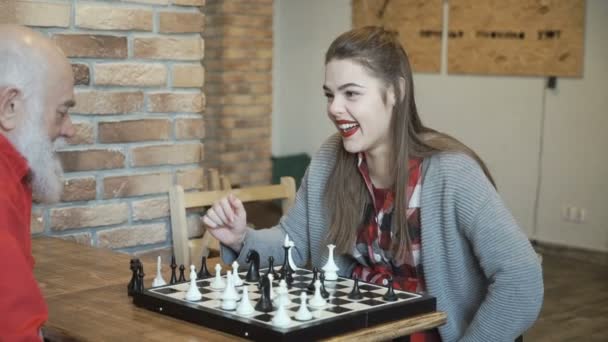 Young beautiful girl play chess with grandfather - Séquence, vidéo