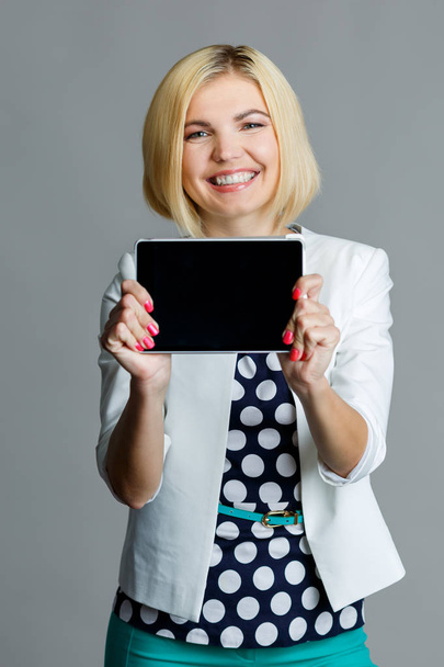 Smiling young blonde holding tablet - Fotó, kép