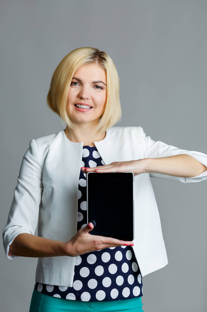 Smiling young woman holding tablet - Φωτογραφία, εικόνα