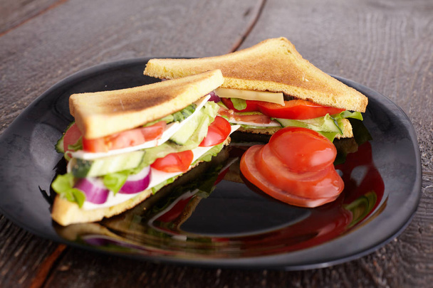 Sağlıklı sandviç yumuşak peynir ve çiğ bahar sebzeler gevrek siyah ekmek üzerinde - Fotoğraf, Görsel