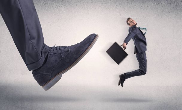 Small businessman kicked by big shoe - Fotó, kép
