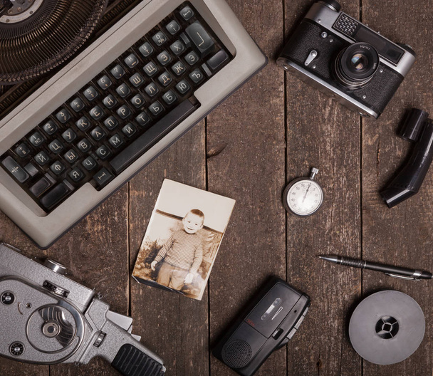 Still life with a typewriter, an old movie camera, a vintage camera on a textured wooden surface - Photo, Image