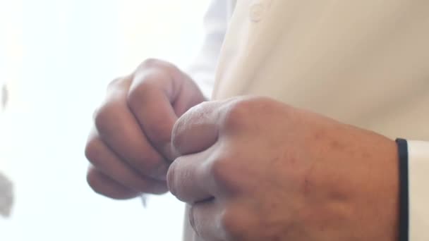 El hombre sujeta los botones de su camisa blanca
. - Metraje, vídeo