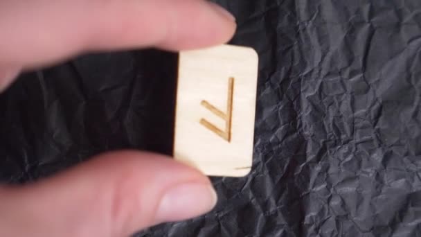 Ansuz omgekeerde rune. Close-up, hand zet de rune op het oppervlak voor divinatie. 4k, slow-motion - Video