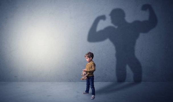 Muscleman shadow behind waggish little boy - Zdjęcie, obraz