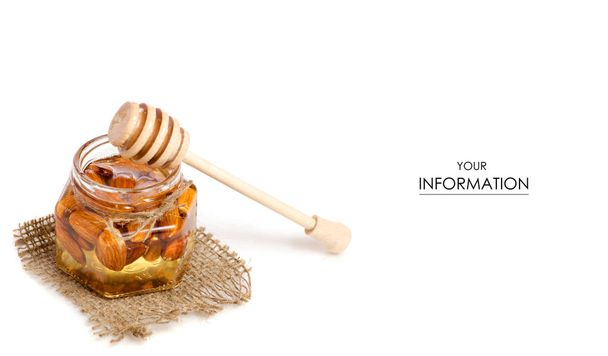 Een pot honing met een lepel honing noten amandelen patroon - Foto, afbeelding