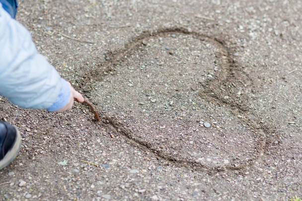 A child draws a heart on earth - Photo, Image