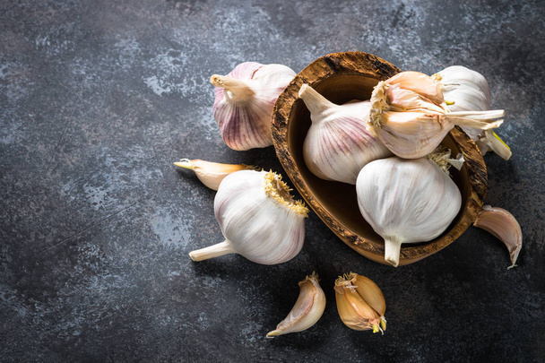 Garlic cloves on a dark stone background.  - Фото, зображення
