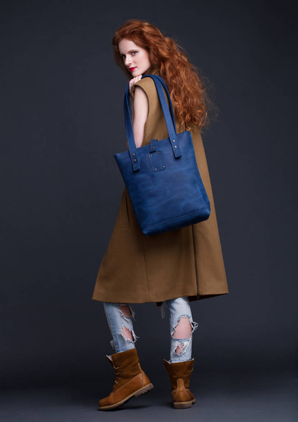 Red hair fashion model holding large leather bag  - Foto, immagini
