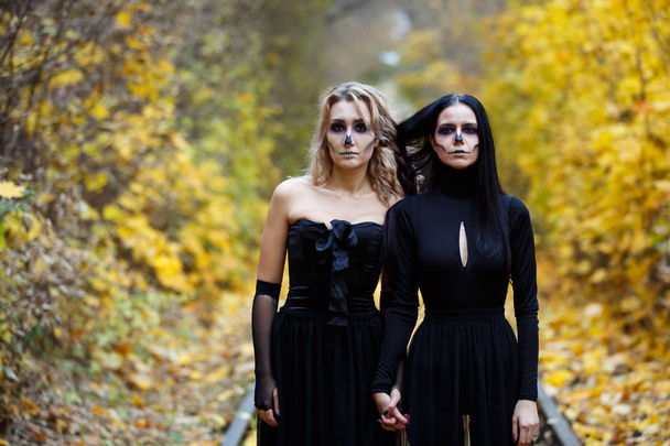 Two vintage witches gathered for the sabbat eve of Halloween.autumn. day, railway rails. - Foto, Imagem