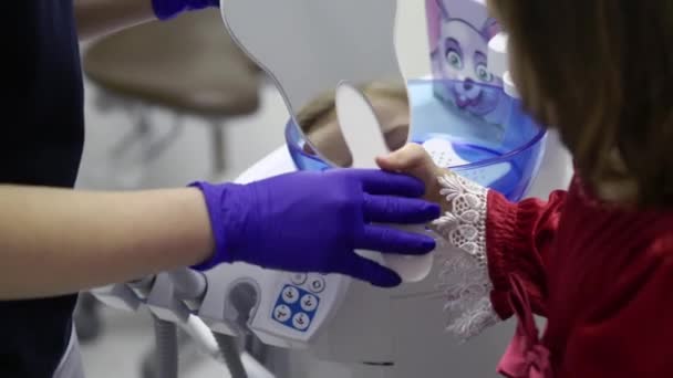 Dítě dívka v zubní klinice při pohledu do zrcadla - Záběry, video
