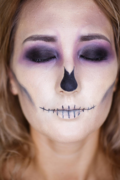 Halloween holidays. Close up portrait of female with skull make up. mouth close up - Фото, изображение