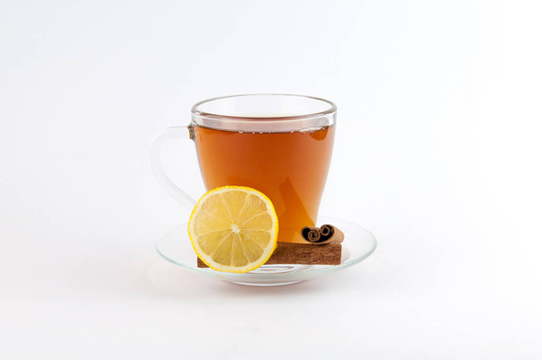 Çay bardağı limon ve beyaz arka plan üzerinde izole tarçın. - Fotoğraf, Görsel