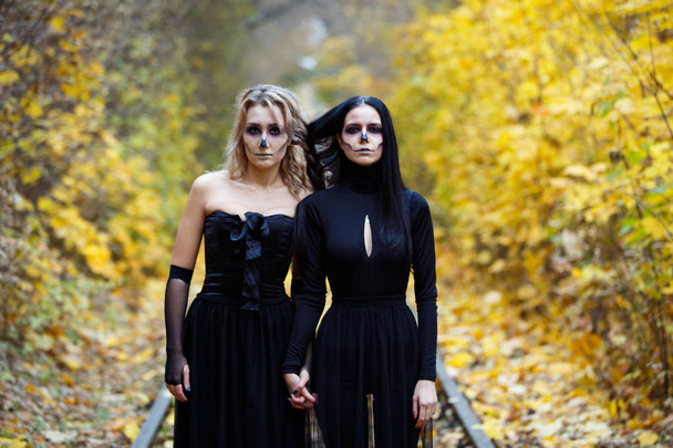 Two vintage witches gathered for the sabbat eve of Halloween.autumn. day, railway rails. - 写真・画像
