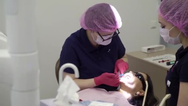 Dentist doctor working with woman patient - Filmati, video