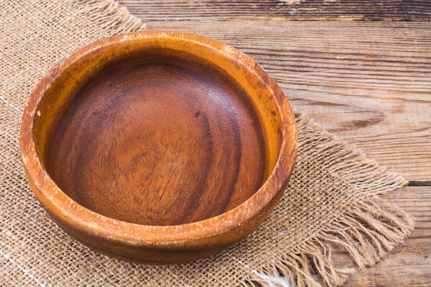 Wooden bowl on burlap, rustic table - Photo, Image