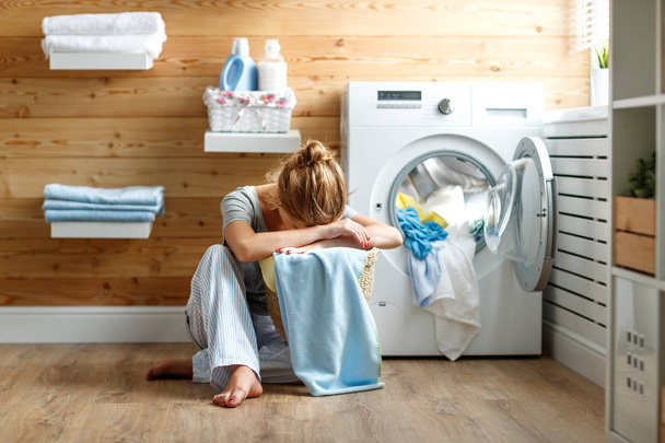 tired housewife woman in stress sleeps in laundry room with wash - Zdjęcie, obraz