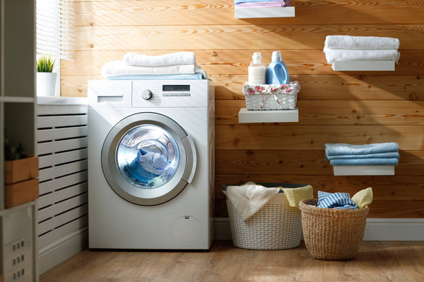Interior da lavandaria real com máquina de lavar roupa na janela em
 - Foto, Imagem
