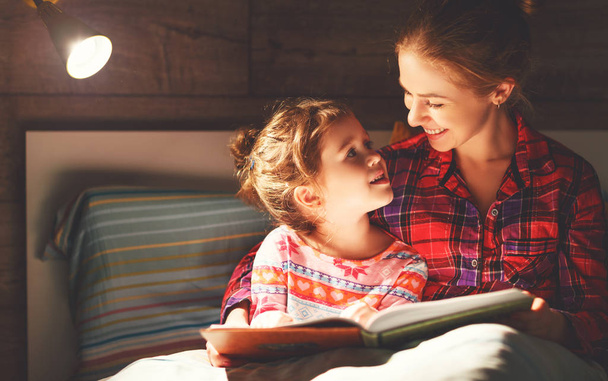 madre y el niño leyendo libro en la cama antes de ir a dormir
 - Foto, imagen