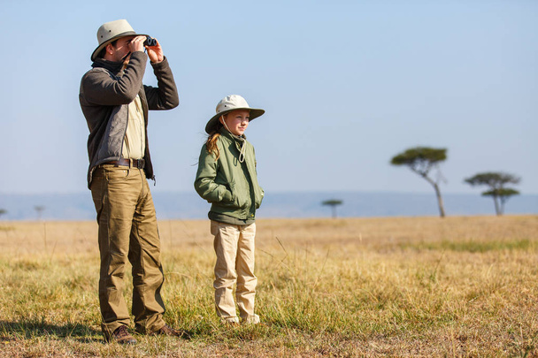 Family of father and child on African safari vacation enjoying bush view - Foto, afbeelding