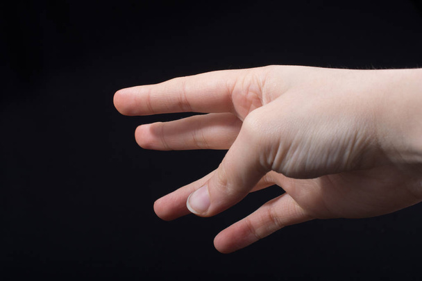 Pět prstů dětské ruky částečně vidět v černém pozadí - Fotografie, Obrázek