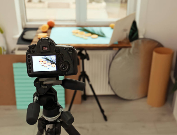 Επαγγελματική φωτογραφική μηχανή με κομμένα φρούτα και φοίνικες φύλλου στην οθόνη στο studio την εικόνα. Φωτογραφία τροφίμων - Φωτογραφία, εικόνα