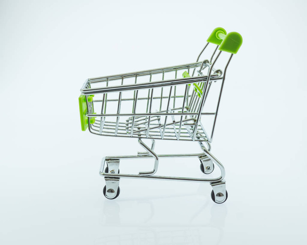 shopping cart on white background, Green small toy shopping cart - Fotó, kép