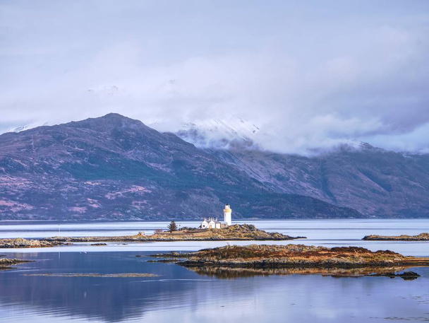 iasle ornsay Leuchtturm auf einer kleinen Insel an der Fährstrecke gebaut. niedriger Pegel glatten Wassers. - Foto, Bild