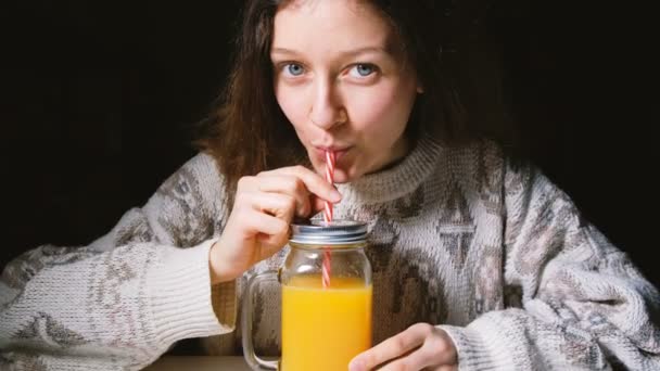 Όμορφη κοπέλα, πίνοντας φρέσκο χυμό πορτοκαλιού σε ένα γυάλινο μπουκάλι με ένα Καλαμάκι - Πλάνα, βίντεο