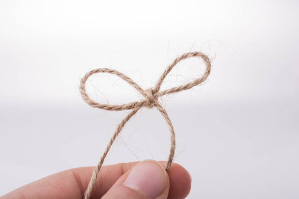 Thread knot in hand on a light color background - Photo, Image