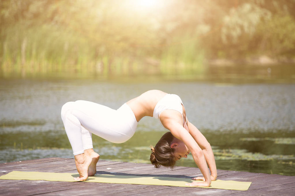 Jeune fille pratique le yoga sur la rive du lac, le concept de jouir de la vie privée et la concentration, la lumière du soleil
 - Photo, image