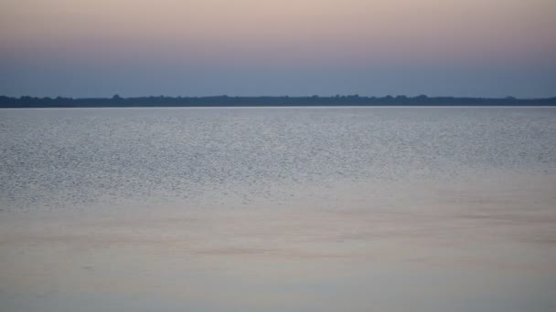 Calma superficie dell'acqua di un lago o di un fiume al tramonto con cielo colorato
 - Filmati, video