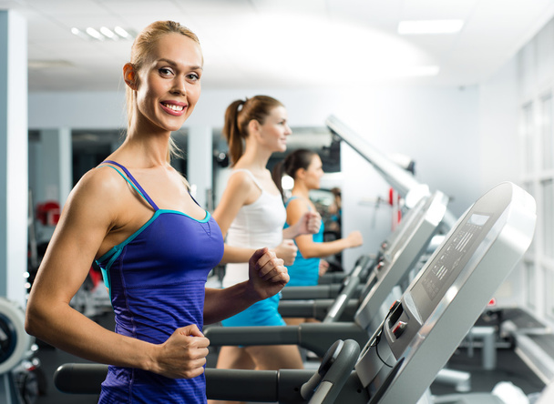 Young women running on a treadmill - Zdjęcie, obraz