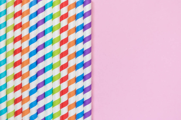 Multicolored drinking paper straws against rose background minimalistic concept - Photo, Image