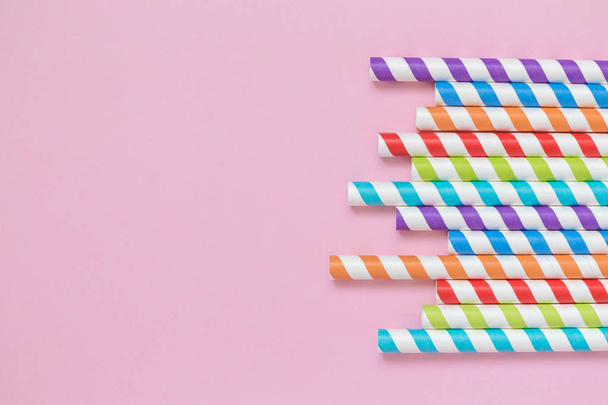 Multicolored drinking paper straws against rose background minimalistic concept - Photo, image
