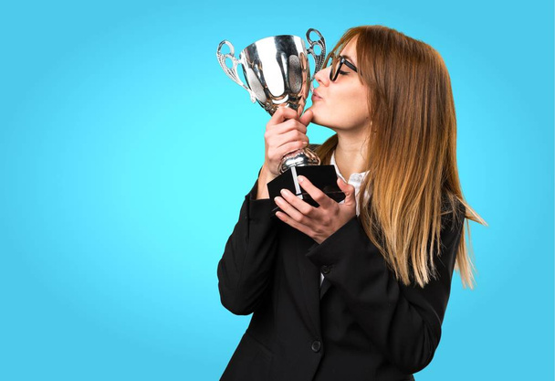 Молодая деловая женщина держит трофей на красочном фоне
 - Фото, изображение